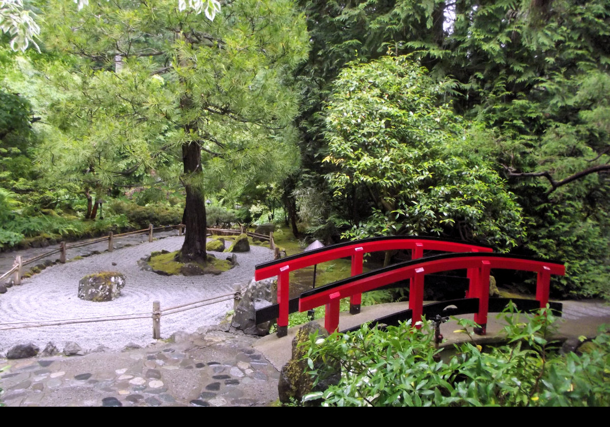 The Zen Garden within the Japanese Garden.  The arched red bridge or Guzei represents wisdom & transformation among a number of experiences.  Red is also symbolic of Zen encouraging those who cross to move from the physical world to a more spiritual world.  It is also very beautiful.  