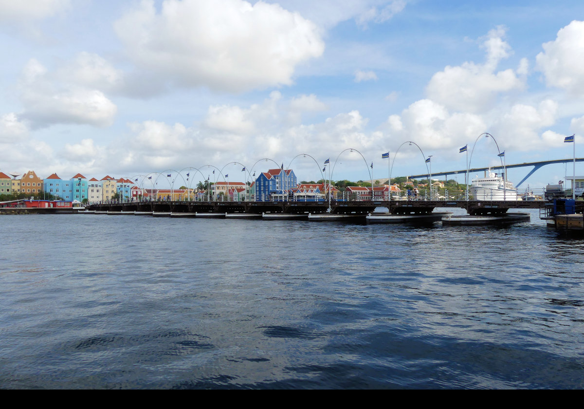  Completed in 1888, & renovated many times since, the Queen Emma Bridge or "Koningin Emmabrug" is a pontoon bridge in Willemstad connecting the Punda & Otrobanda districts across St. Anna Bay.  Using a system of propellers, the bridge can swing around parallel to the bank to allow large ships to pass.  When this occurs, two free ferries are used for pedestrains.  Pedestrian only since 1974