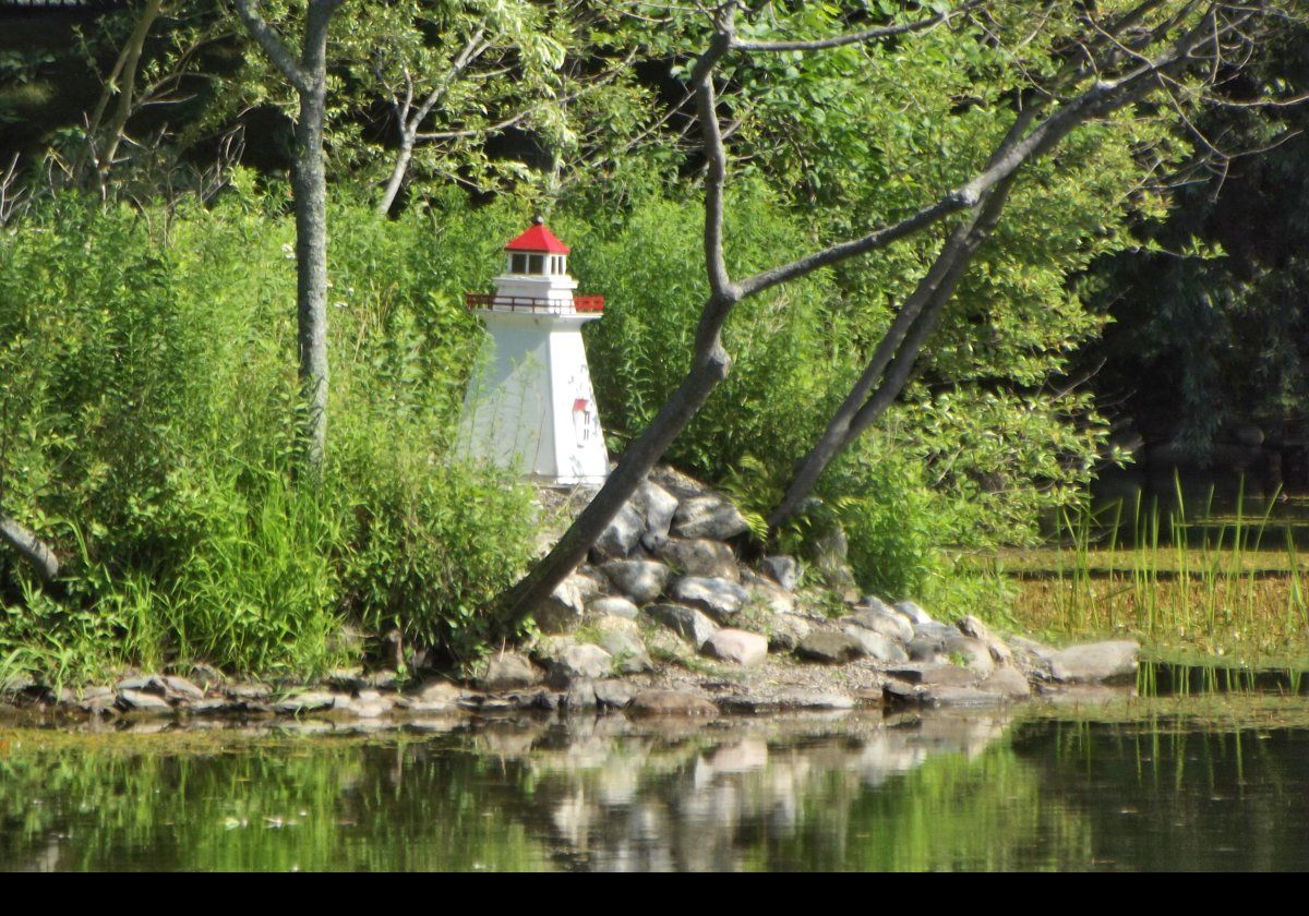 A model of a lighthouse on the edge of the duck pond.