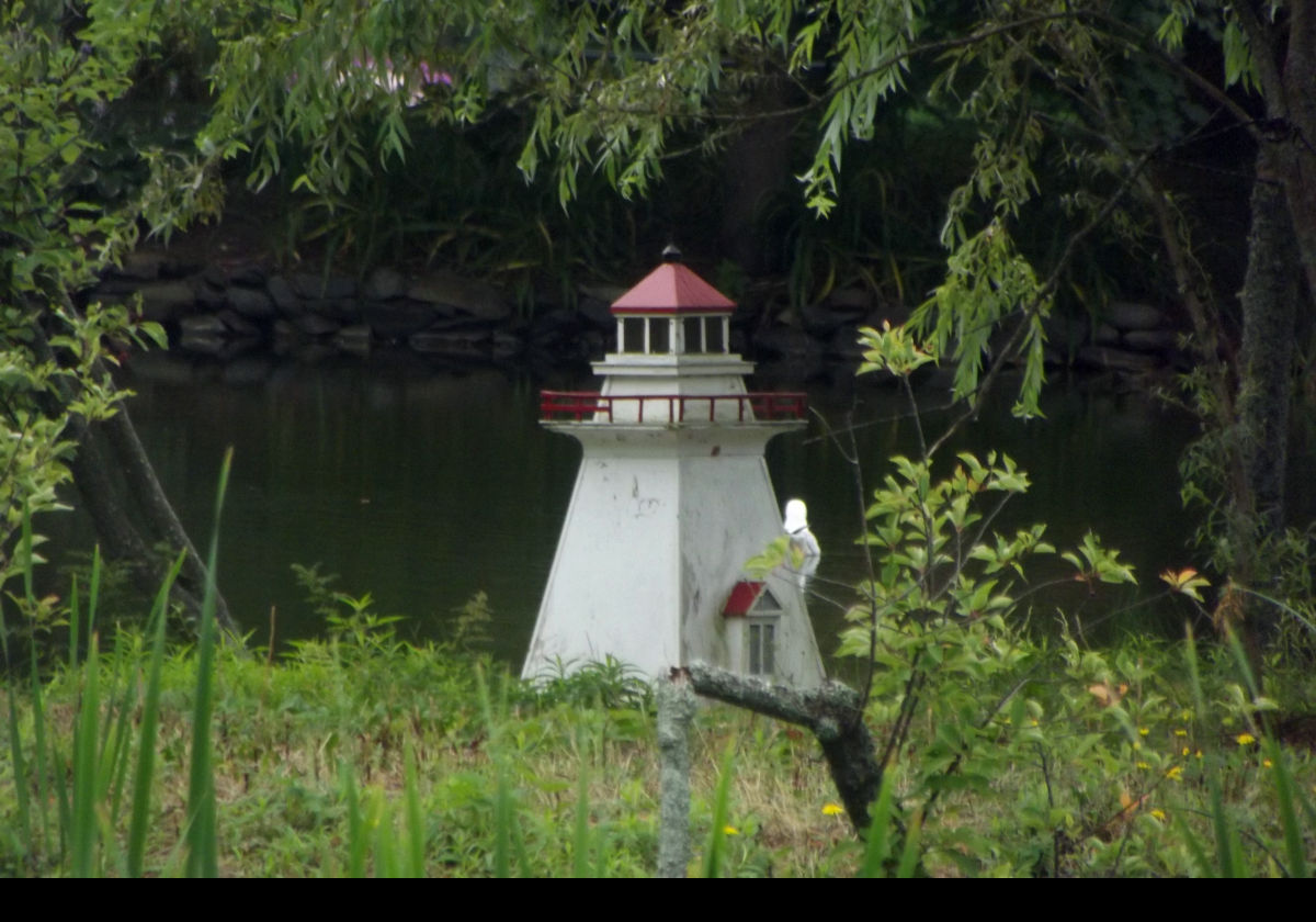 Another view of the model of a lighthouse on the edge of the duck pond.
