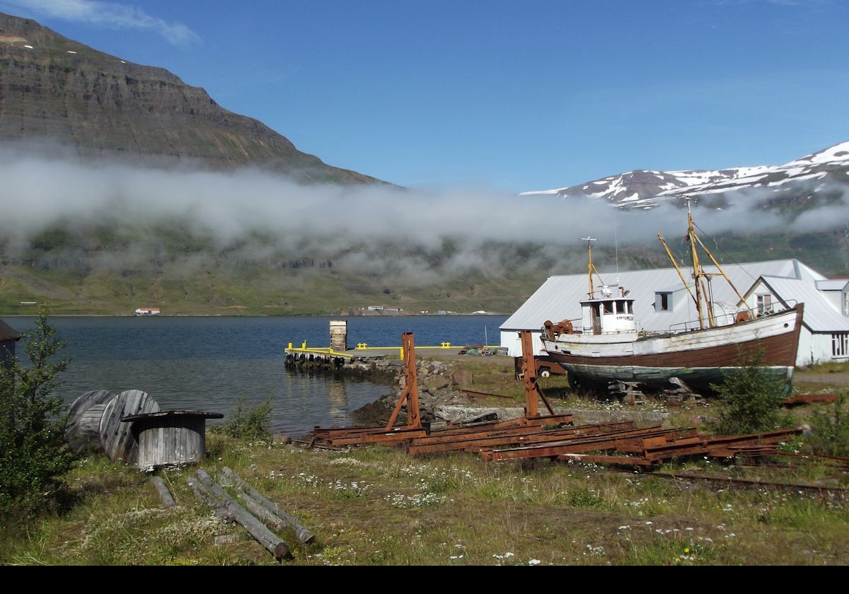A boat pulled out of the water on the coast of the fjord also known as Seyðisfjörður.  