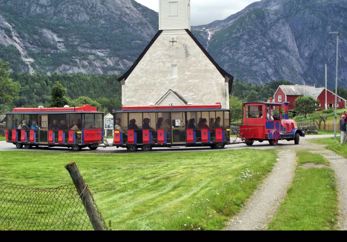 The tourist "train" on a tour of Eidfjord passing the Old Eidfjord Church.