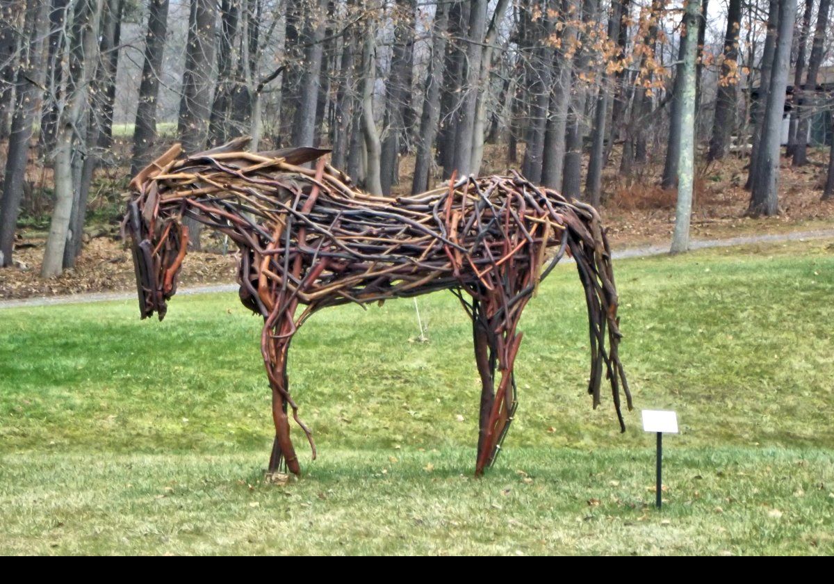 Outside the museum, there is a horse sculpture titled "Tres Bien".  It was made from driftwood in 2014 by Rita Dee.